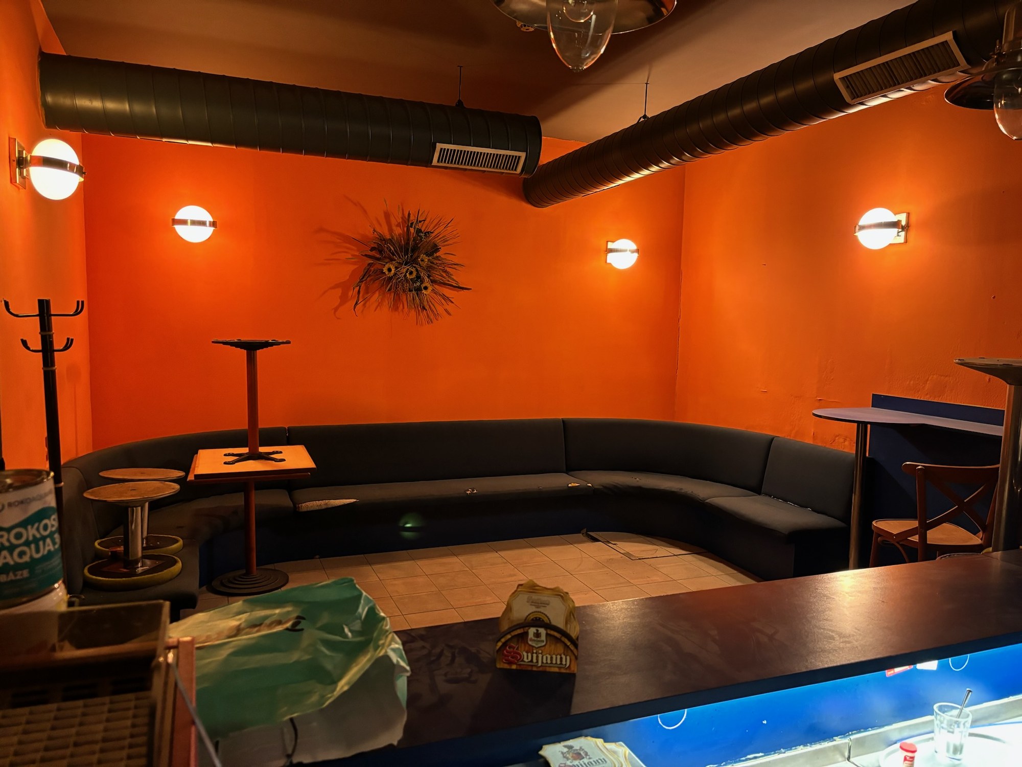 The bar area before, orange walls and old furniture