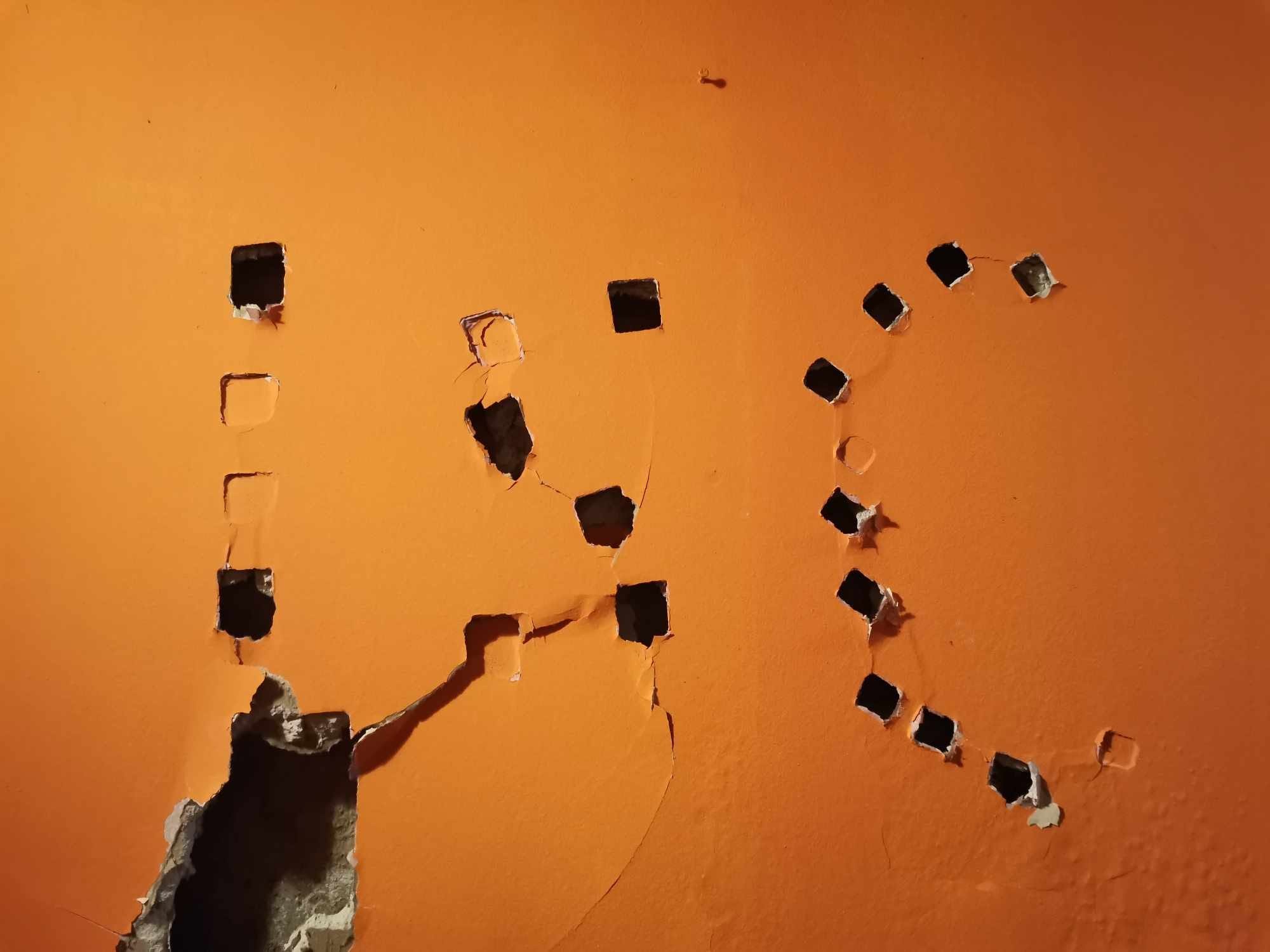 Painting the letters ISC onto an orange wall