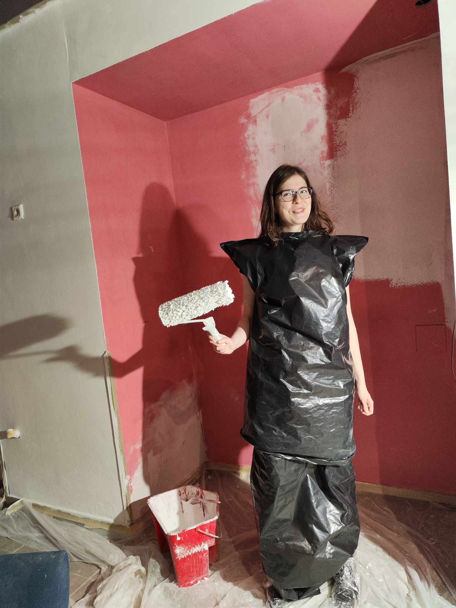 Painting a wall, wearing a bin bag over clothes