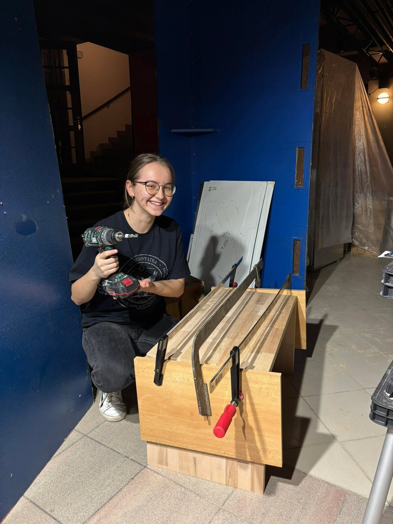 A club member with a cordless drill next to a half-built bench