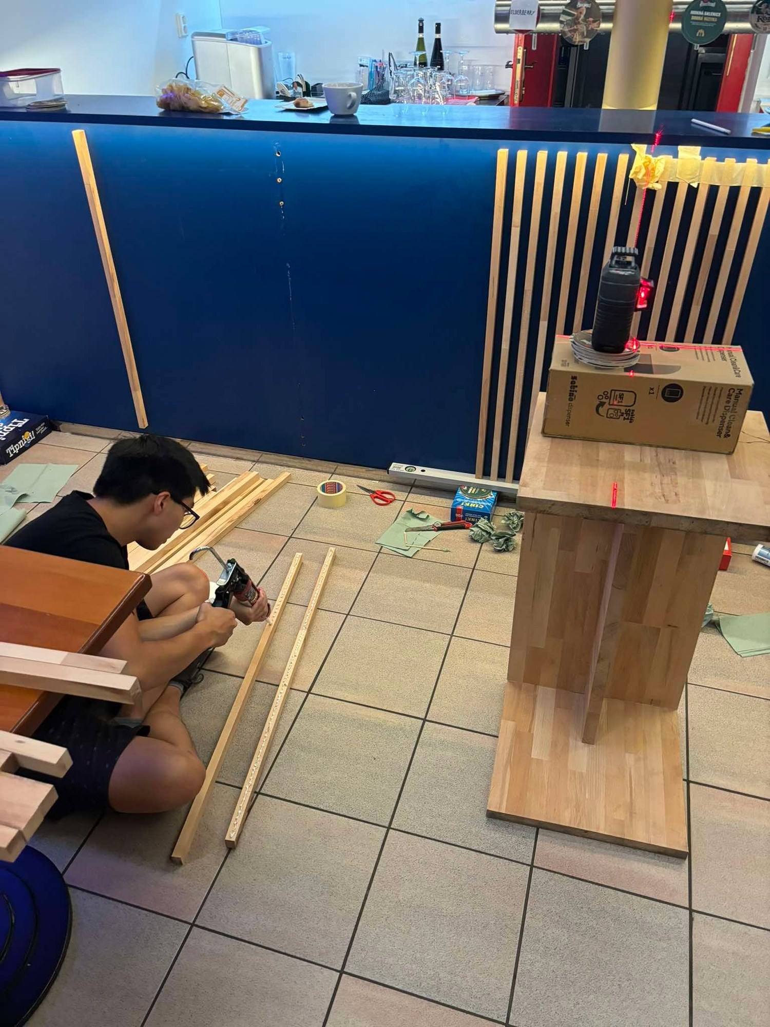 Assembling wooden furniture on the floor in front of the bar